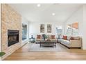 Stylish living room with a stone fireplace, hardwood floors, neutral tones, and modern decor at 7204 W Mcrae Way, Glendale, AZ 85308