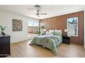 Cozy main bedroom with a wood accent wall, ceiling fan, and natural light at 7204 W Mcrae Way, Glendale, AZ 85308