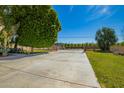 Long driveway leading to the home, framed by green lawn, bushes, and a gate at 7804 S 15Th Ave, Phoenix, AZ 85041