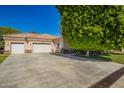 Exterior shot with a three-car garage and spacious driveway surrounded by mature landscaping at 7804 S 15Th Ave, Phoenix, AZ 85041
