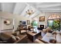 Spacious living room with vaulted ceilings, lots of seating, tile floors, and a cozy fireplace at 7955 E Chaparral Rd # 73, Scottsdale, AZ 85250