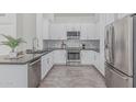Modern kitchen with white cabinets, stainless steel appliances, granite countertops, and stylish tile backsplash at 921 N Oxford Ln, Chandler, AZ 85225