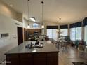 Spacious kitchen featuring a large island, modern appliances, skylight, and an adjacent dining area at 9733 W Mcrae Way, Peoria, AZ 85382