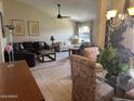 Bright and inviting living room with neutral tones, tile flooring, and large windows for natural light at 9733 W Mcrae Way, Peoria, AZ 85382