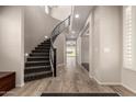 Elegant foyer with a curved staircase, tile flooring, and modern lighting for a grand entrance at 14674 W Pasadena Ave, Litchfield Park, AZ 85340
