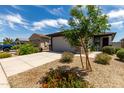 Charming home featuring a well manicured front yard with beautiful desert landscaping at 17437 W Via De Luna Dr, Surprise, AZ 85387