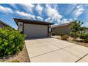 Home exterior featuring a two car garage and manicured landscaping at 17437 W Via De Luna Dr, Surprise, AZ 85387