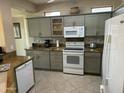 Well-lit kitchen featuring neutral-toned cabinets, granite countertops, and modern white appliances at 19139 N Alameda Dr, Surprise, AZ 85387