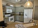 Bright kitchen featuring granite countertops, light-colored cabinets, tile floors, and white appliances at 19139 N Alameda Dr, Surprise, AZ 85387