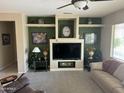 Cozy living room with a decorative fireplace, built-in shelving, and comfortable seating at 19139 N Alameda Dr, Surprise, AZ 85387