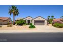 Inviting single-story home with a well-maintained front yard, lush greenery, and a two-car garage at 19892 N Shadow Mountain Dr, Surprise, AZ 85374