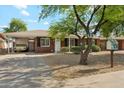 Single-story brick home featuring covered parking and xeriscaped front yard for easy maintenance at 2015 W Weldon Ave, Phoenix, AZ 85015