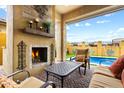 Inviting patio with cozy fireplace, comfortable outdoor seating, and a clear view of the refreshing pool at 2114 N Canelo Hls, Mesa, AZ 85207