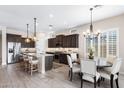 Elegant kitchen with dark wood cabinets, a granite island with seating, and stainless steel appliances at 2114 N Canelo Hls, Mesa, AZ 85207