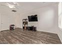 Living room with wood floors, large TV, minimalist furniture, and bright natural light at 22125 N 29Th Ave # 137, Phoenix, AZ 85027
