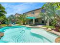 Beautiful backyard pool with palm trees and lounge chairs for relaxing and enjoying the outdoors at 23523 N 117Th Dr, Sun City, AZ 85373