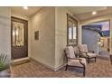 Inviting front porch with wrought iron door, cozy seating, and stylish brick pavers at 3750 E Rochelle Cir, Mesa, AZ 85215