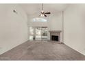 Open living room with a fireplace and a sliding door to the backyard and neutral tones at 4544 E Campo Bello Dr, Phoenix, AZ 85032