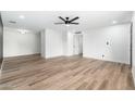A bright, open-concept living room with wood-look floors and a modern ceiling fan at 4922 W Coolidge St, Phoenix, AZ 85031