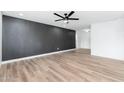 Spacious living room with a dark accent wall, wood-look flooring, and ample natural light at 4922 W Coolidge St, Phoenix, AZ 85031