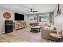 Cozy living room with a large sectional sofa, modern ceiling fan, and decorative rug on wood-look floors at 5325 E Thunderbird Rd, Scottsdale, AZ 85254