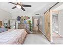Spacious bedroom with ceiling fan, decorative baskets on the dresser, and a sliding barn door to the bathroom at 5325 E Thunderbird Rd, Scottsdale, AZ 85254