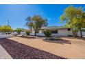 Landscaped front yard featuring decorative gravel accents and mature trees adding charm to the property's exterior at 5539 E Dahlia Dr, Scottsdale, AZ 85254