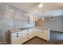 Kitchen with white cabinets, wood look flooring, stone countertops and open to living area at 717 W Chilton St, Chandler, AZ 85225