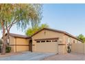 View of the front of a single-story home with a two-car garage and manicured yard at 7607 W Keim Dr, Glendale, AZ 85303