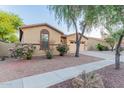 Single-story home showcasing desert landscaping, a two-car garage, and charming curb appeal at 7607 W Keim Dr, Glendale, AZ 85303