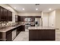 Modern kitchen with stainless steel appliances, island, and dark wood cabinetry at 7769 W Bonitos Dr, Phoenix, AZ 85035