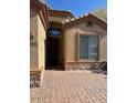 Home featuring stone accents, a covered entryway, and a paver walkway to the front door at 840 W Crooked Stick Dr, Casa Grande, AZ 85122
