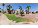 Expansive single-story home with desert landscaping, a circular driveway, and towering palm trees at 9208 N 83Rd St, Scottsdale, AZ 85258
