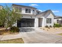 Contemporary home showcases a gray garage door and xeriscaped front yard, blending style and sustainability at 10034 E Thunderbolt Ave, Mesa, AZ 85212