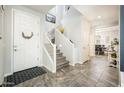 Bright foyer features a staircase, modern tile flooring, white walls, and accents creating a welcoming atmosphere at 1151 S Avoca --, Mesa, AZ 85208