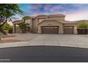 Elegant two-story home featuring a three-car garage, desert landscaping, and a tile roof at 14049 S 8Th St, Phoenix, AZ 85048