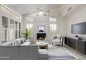 Bright living room with vaulted ceilings, large windows, a fireplace, and modern furnishings at 14470 N 98Th Pl, Scottsdale, AZ 85260