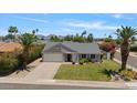 Charming single-story home with a well-manicured lawn, lush landscaping, and attached two-car garage at 16409 N 65Th Pl, Scottsdale, AZ 85254