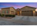 Charming single-Gathering home featuring desert landscaping, multi-car garage, and a welcoming facade under a beautiful twilight sky at 21283 E Camacho Rd, Queen Creek, AZ 85142