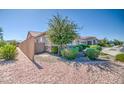 Landscaped front yard featuring decorative gravel and mature trees, providing a serene and inviting curb appeal at 21551 E Waverly Ct, Queen Creek, AZ 85142