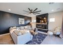 A spacious living room featuring hardwood floors, a modern fireplace, and contemporary furnishings at 2158 N 212Th Ave, Buckeye, AZ 85396