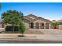 Inviting single-story home with a well-manicured front yard, desert landscaping, and an arched covered porch at 21720 E Domingo Rd, Queen Creek, AZ 85142