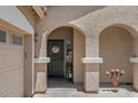 Single-story home featuring an arched covered porch with desert landscaping leading to the main entrance at 21720 E Domingo Rd, Queen Creek, AZ 85142