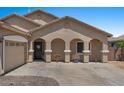 Welcoming single-story home with an arched covered porch and desert landscaping with a spacious driveway at 21720 E Domingo Rd, Queen Creek, AZ 85142