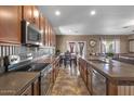 Well-equipped kitchen with stainless steel appliances, a dining area, and an adjacent living space at 21720 E Domingo Rd, Queen Creek, AZ 85142