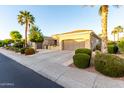 Attractive home with a three car garage, beautiful desert landscaping, and mature palm trees at 23213 N Del Monte Dr, Sun City West, AZ 85375