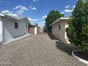 A low-maintenance backyard featuring gravel landscaping, a metal gate, and block fencing at 235 N 61St Pl, Mesa, AZ 85205