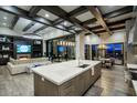 A modern kitchen and living room featuring a marble island, designer lighting, and open floor plan at 24066 N 90Th Way, Scottsdale, AZ 85255