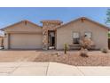 Charming single-story home with a brick-paved driveway and beautiful desert landscaping at 25667 W Primrose Ln, Buckeye, AZ 85326