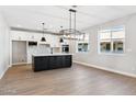 Modern kitchen featuring a large island, stainless steel appliances, and hardwood floors at 25894 W White Feather Ln, Wittmann, AZ 85361